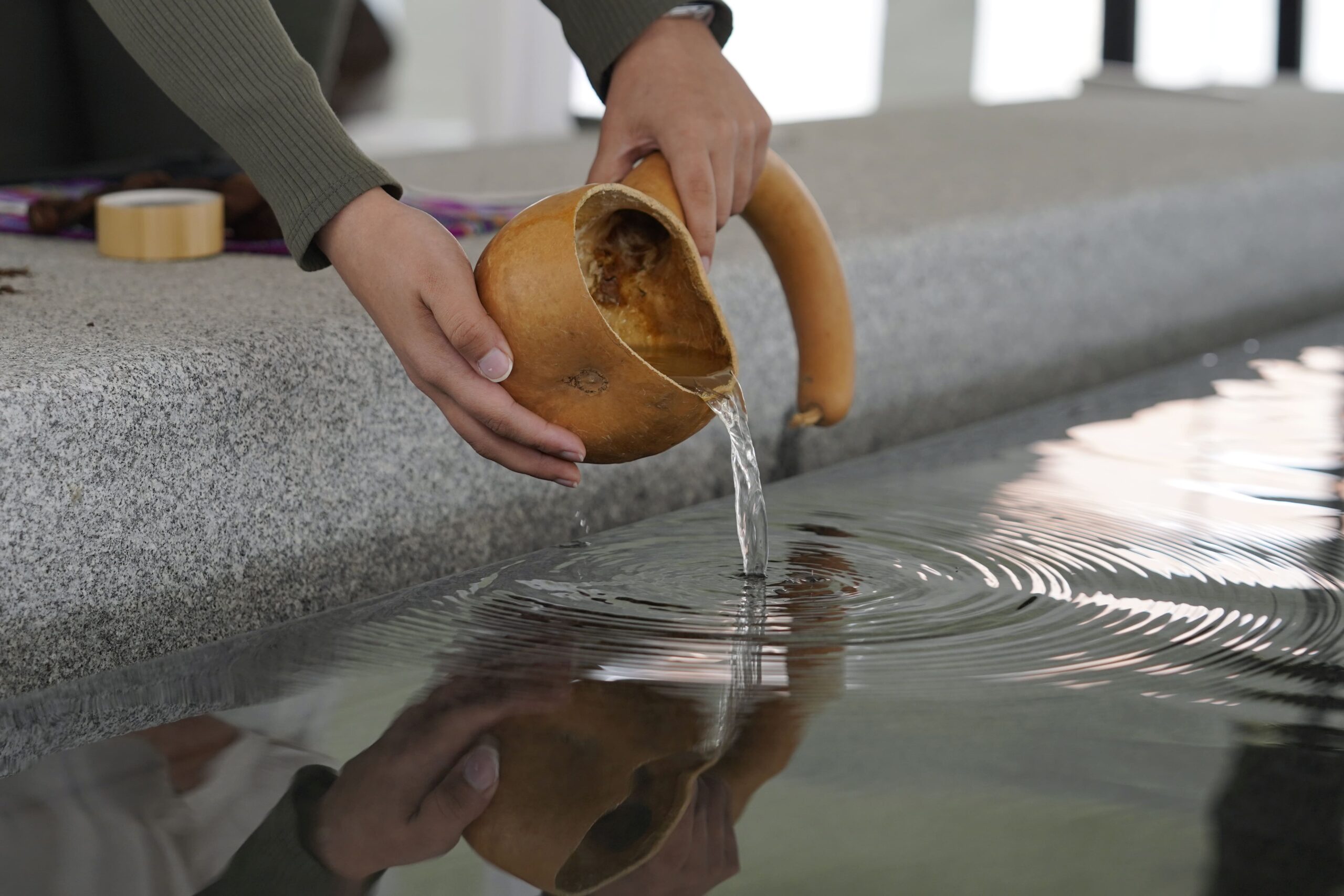 Professor Gabrielle Tayac pours water from the Potomac into the Wilkins Plaza<br />
fountain, which contains stones in a pattern that symbolize an African custom of gathering<br />
and prayer, in a ceremony acknowledging that the land on which the university was built<br />
was originally inhabited by indigenous people.